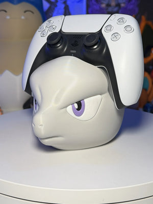 Supporto controller a forma di testa di personaggio anime grigio con occhi viola, su tavolo bianco