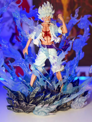 Action figure Monkey D. Luffy Gear 5 One Piece con effetti energia blu, base rocciosa.