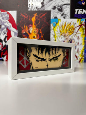 Light box decorativa con volto di Guts da Berserk, sfondo anime colorato, scrivania bianca.