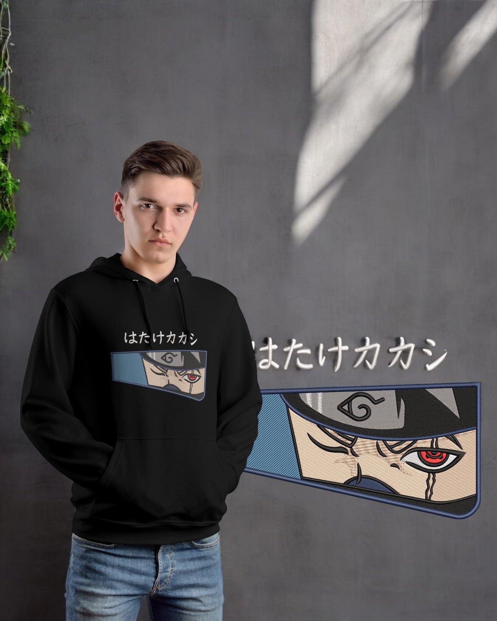 Felpa nera anime ricamata con occhio sharingan, ispirata a personaggio giapponese, su sfondo grigio.
