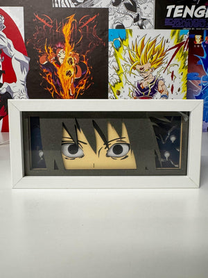 Light box decorativo anime con occhi di Sasuke Sharingan da Naruto in cornice bianca, sfondo manga.