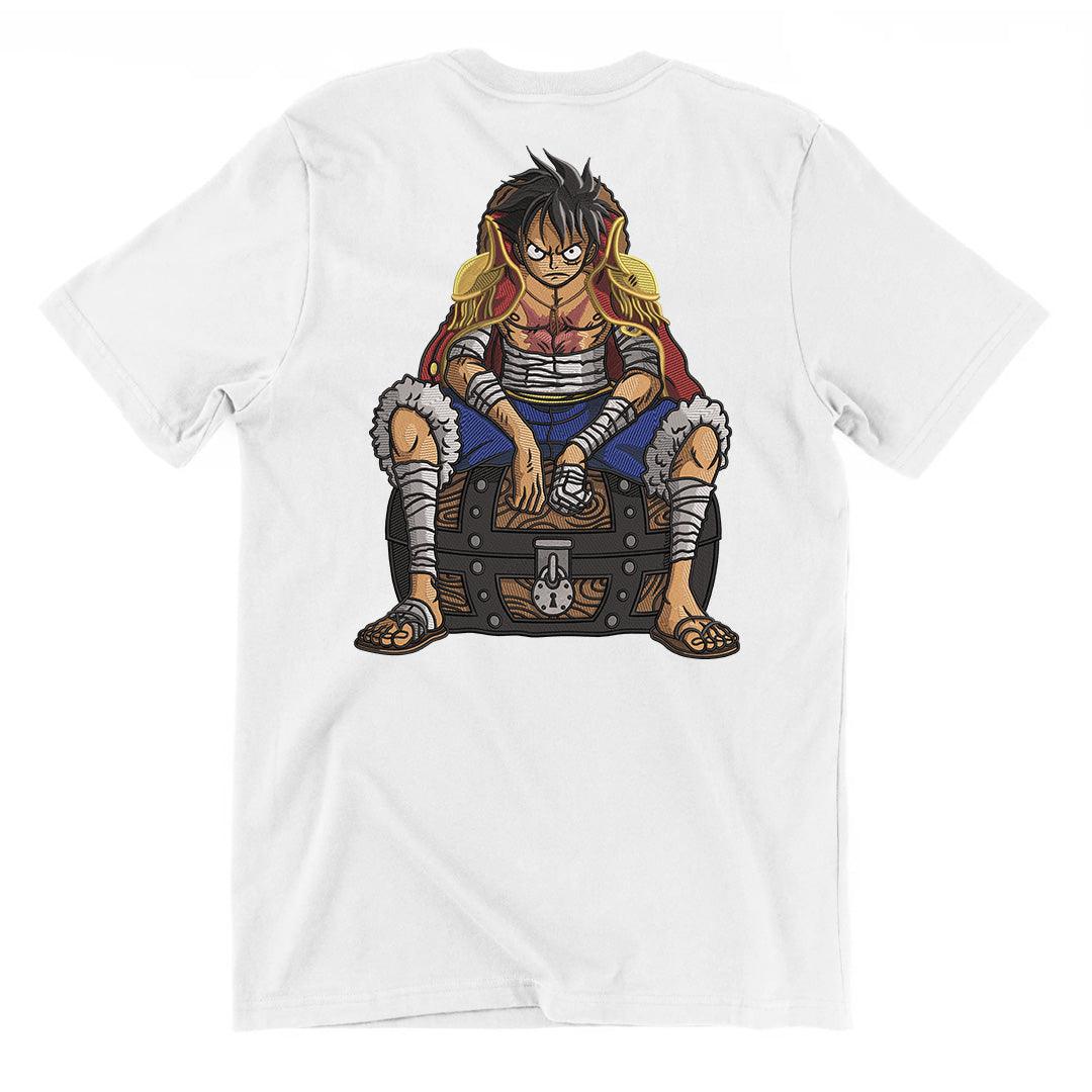 T-shirt bianca con ricamo di personaggio anime seduto su forziere, stile One Piece.