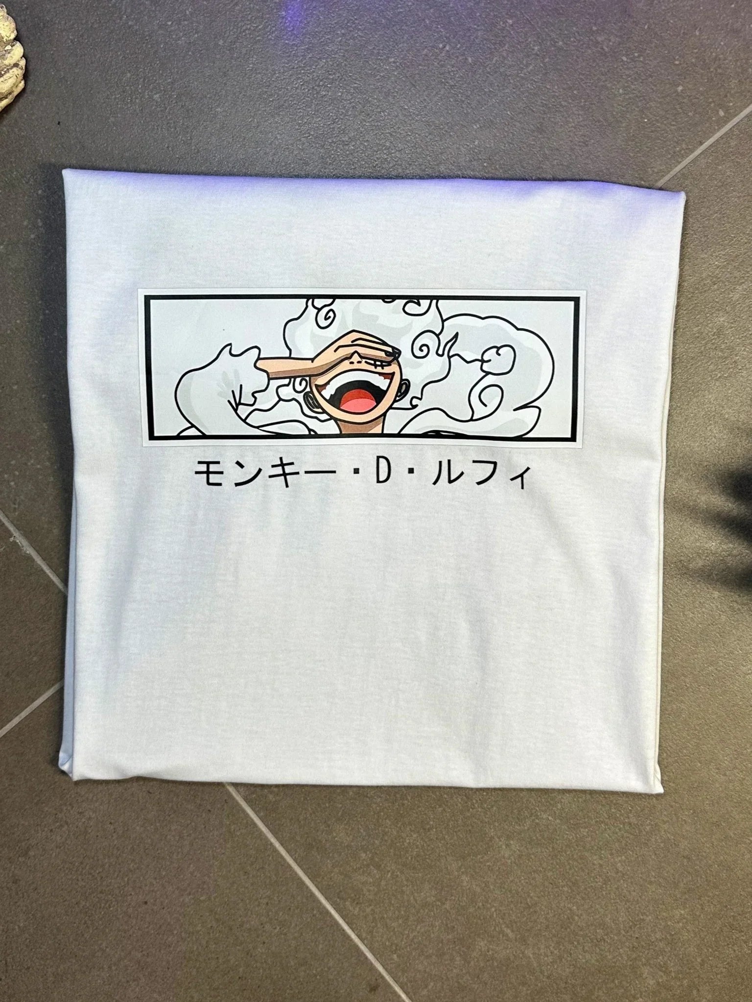 Maglietta bianca anime con stampa Luffy Gear 5 e scritte giapponesi, stile One Piece.