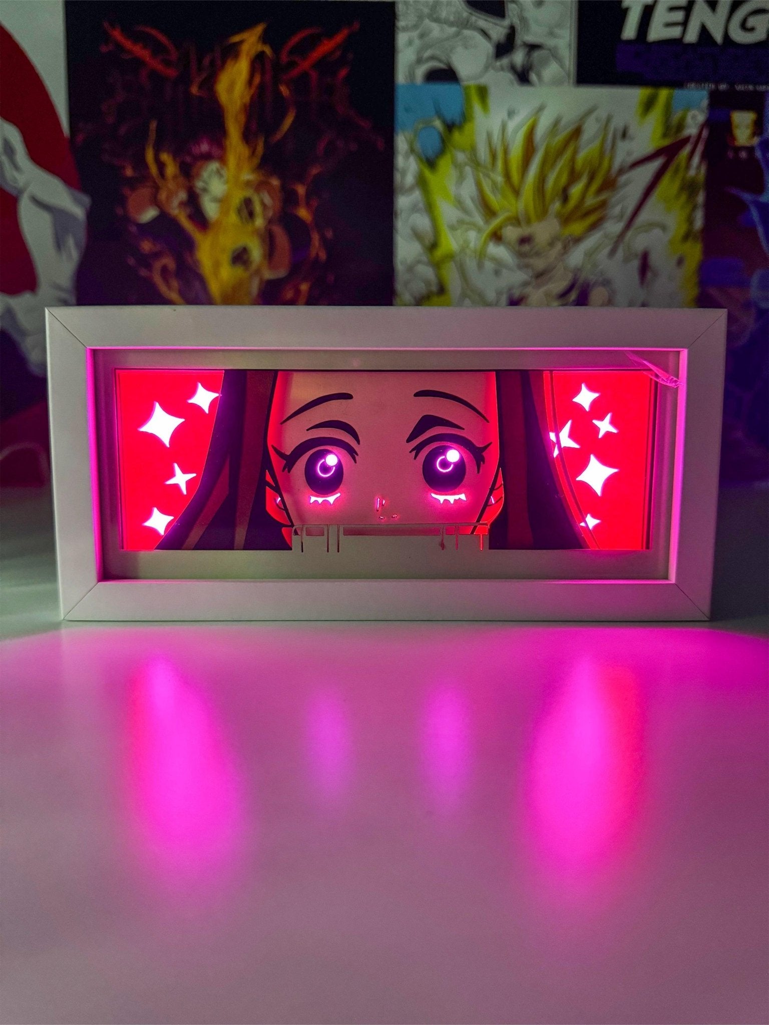 Light box anime con volto di Nezuko da Demon Slayer illuminato da luci rosa decorative.
