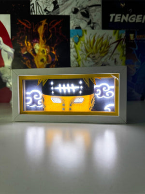 Light box anime raffigurante occhi Rinnegan e simboli nuvola, illuminato su scrivania.