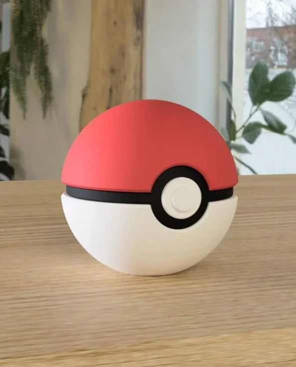 Pokeball classica da collezione con base magnetica su tavolo in legno, stile anime.