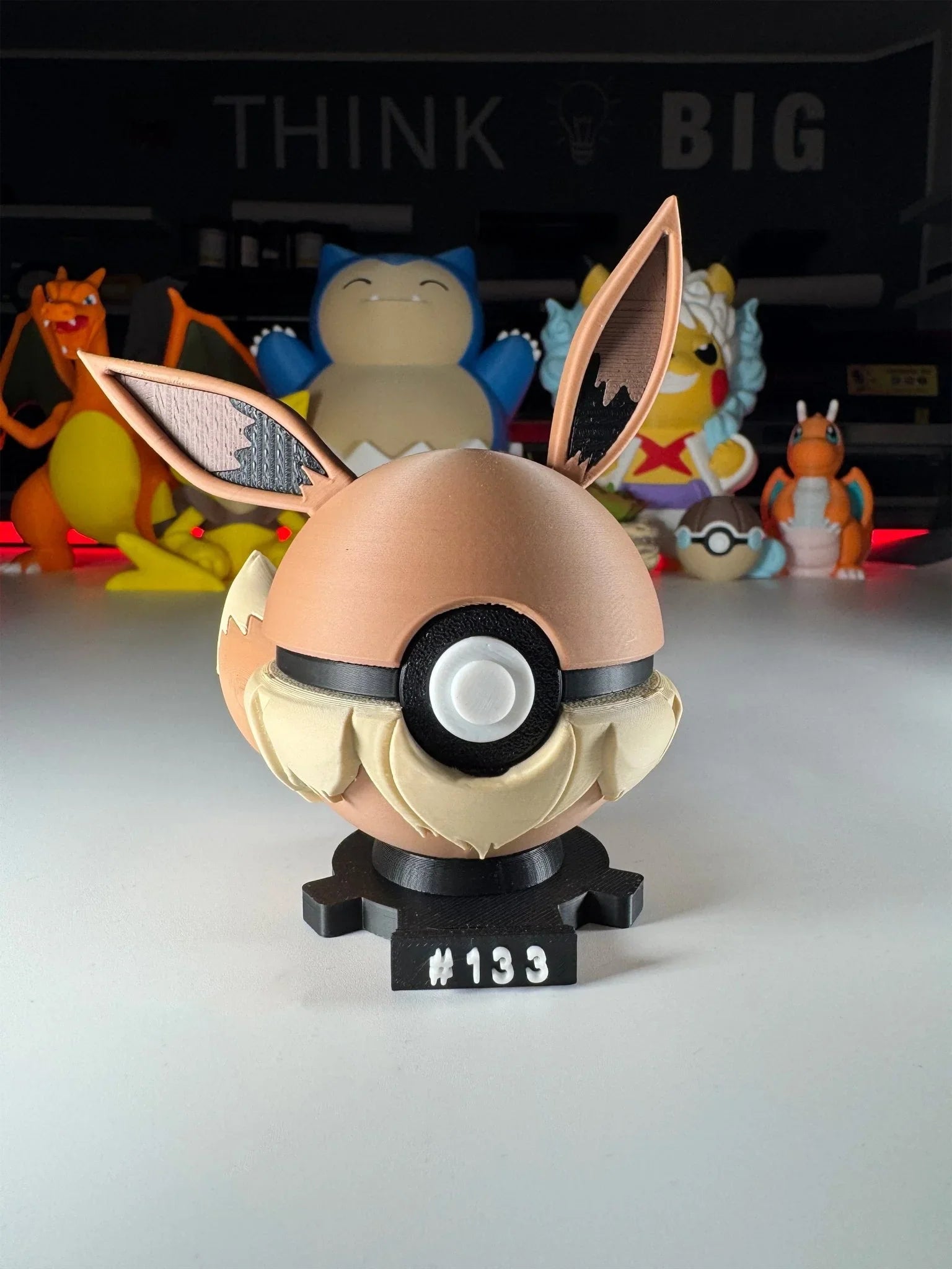 Pokeball a forma di Eevee numero 133 con base magnetica, statuine Pokémon sullo sfondo