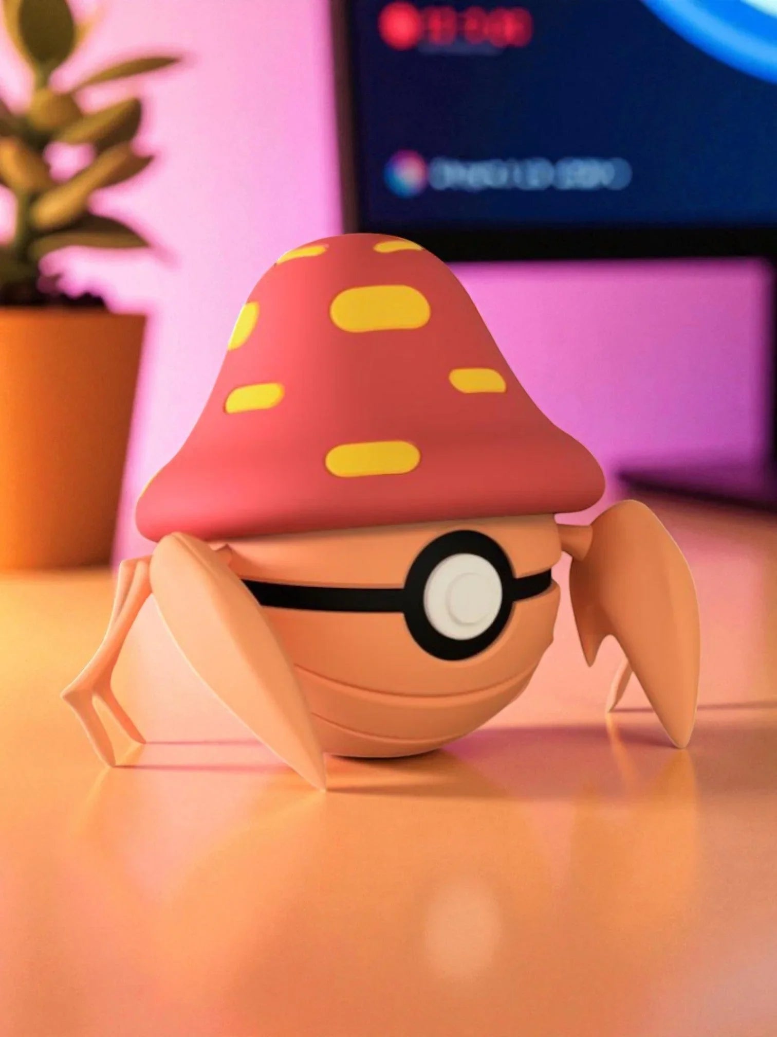Figura Parasect stile Poké Ball da collezione su scrivania, sfondo rosa, dettaglio magnetico.