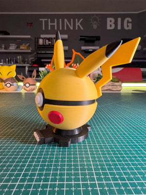 Pokeball ispirata a Pikachu con base magnetica, figura decorativa anime su tavolo da lavoro.