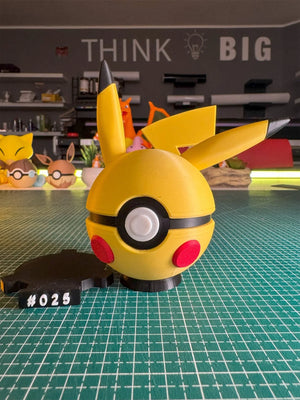 Pokeball ispirata a Pikachu con orecchie gialle, base magnetica numerata e sfondo artigianale.