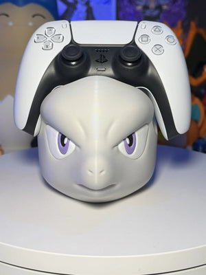 Supporto per controller PS5 a forma di Mewtwo Pokémon stampato in 3D, su tavolo bianco