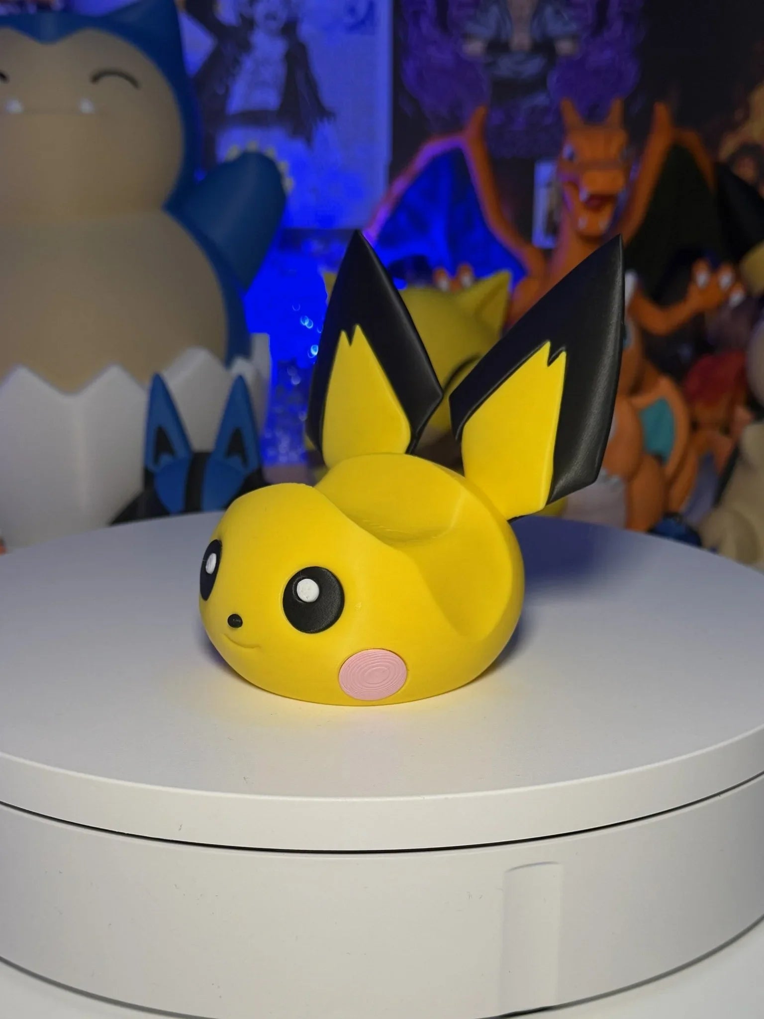 Porta controller 3D a forma di Pichu Pokémon giallo per PS5, Xbox e Switch, con altri personaggi anime sullo sfondo.