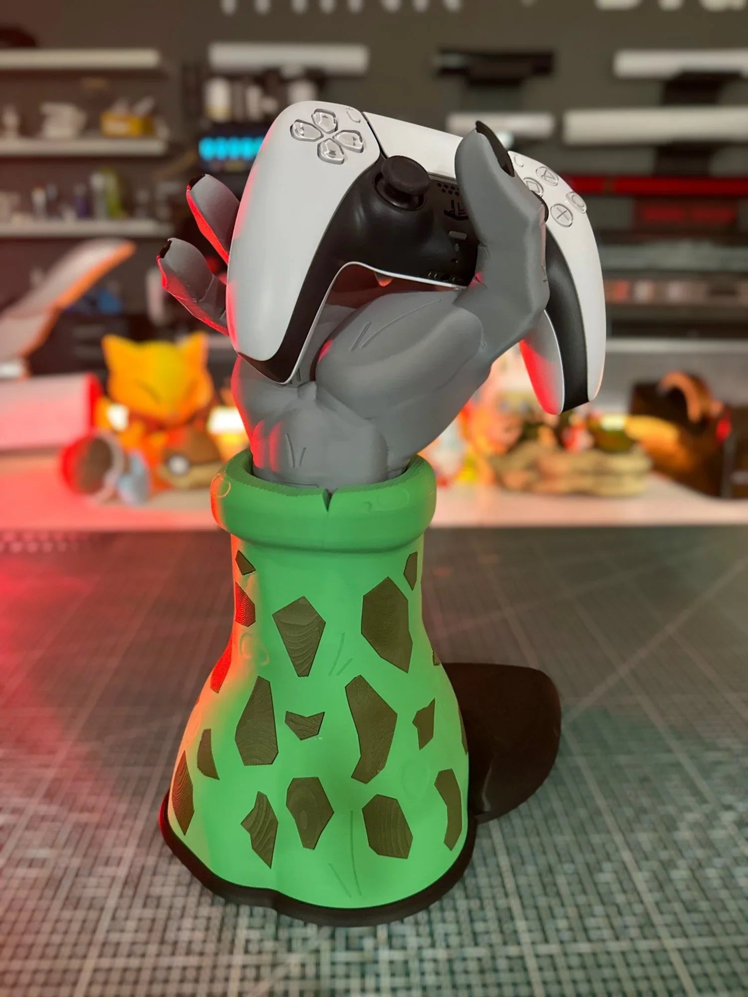 Supporto controller a forma di mano verde ispirato a Cell di Dragon Ball Z, con joypad.