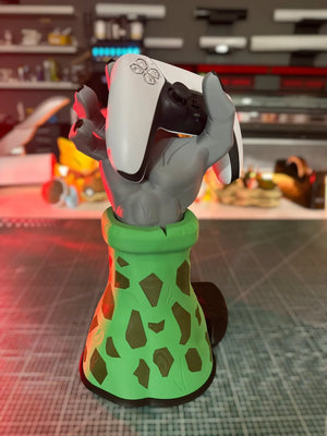 Supporto per controller ispirato a Dragon Ball Z, mano grigia con base verde decorata, regge un controller di gioco