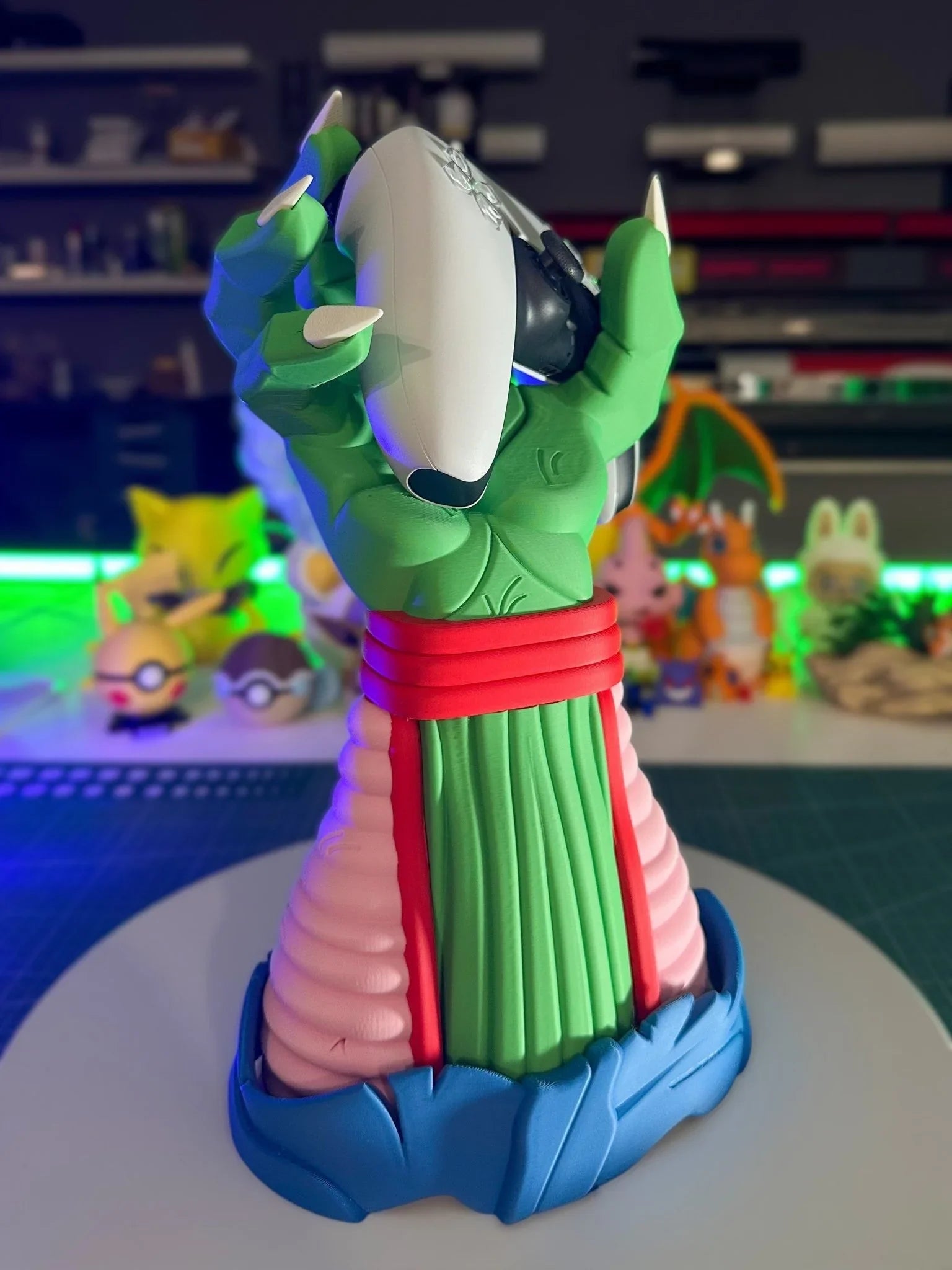 Supporto porta controller a forma di mano verde di drago, ispirato a Dragon Ball, su scrivania nerd.