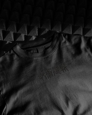 T-shirt nera ricamo Jujutsu Kaisen caratteri giapponesi frontali, stile anime