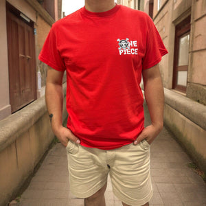 T-shirt rossa anime One Piece con logo Mugiwara, indossata da uomo in strada.