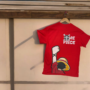 Maglietta rossa One Piece con stampa di Luffy e logo Mugiwara, appesa a una parete.