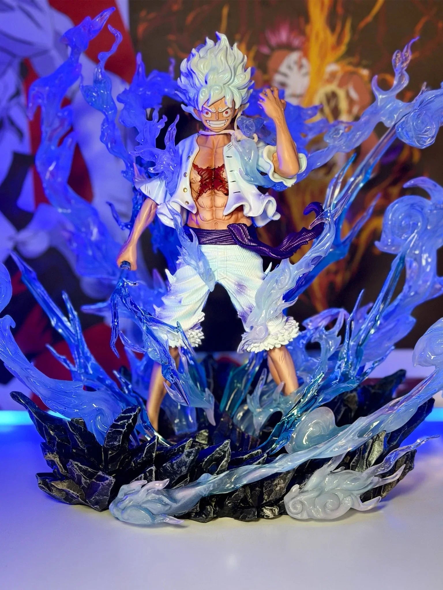 Action figure di Monkey D. Luffy Gear 5 One Piece con effetto energia blu su base rocciosa
