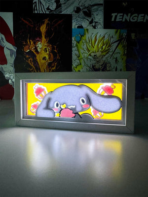 Lampada light box con personaggio kawaii con orecchie lunghe, sfondo giallo e cupcake