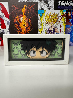 Light box Deku My Hero Academia in cornice bianca, sfondo con poster anime colorati.