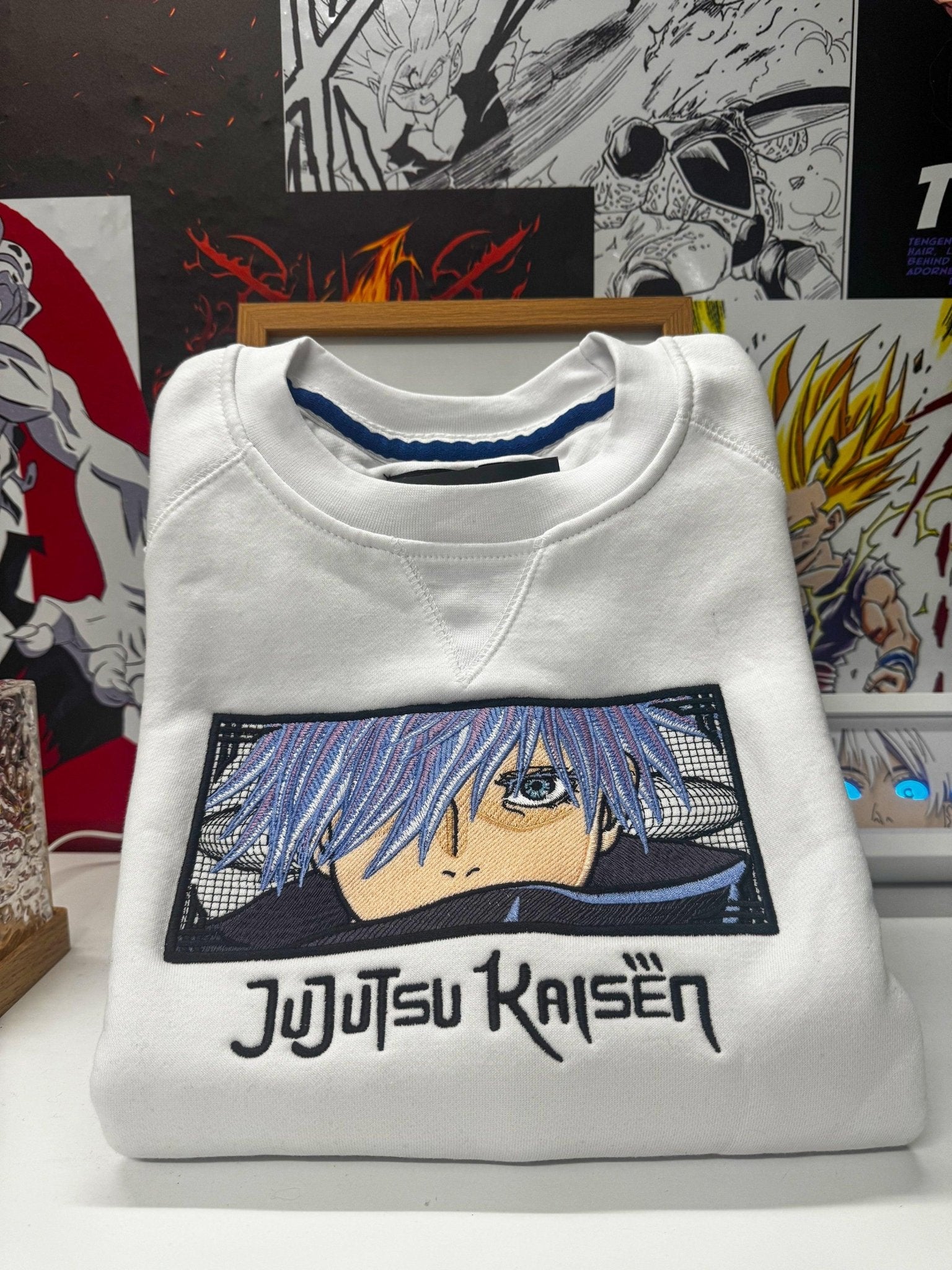 Felpa bianca ricamata Gojo Satoru Jujutsu Kaisen, piegata su sfondo anime, 100% Made in Italy.