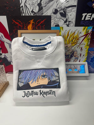 Felpa bianca anime ricamata con Gojo Satoru e logo Jujutsu Kaisen, stile manga giapponese.