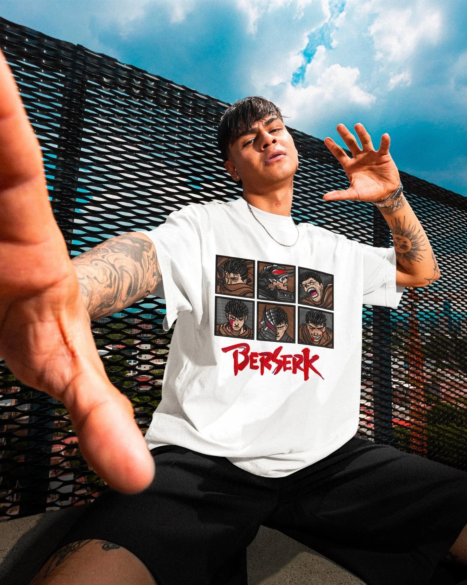 Ragazzo indossa t-shirt bianca anime Berserk con ricamo di Guts, streetwear premium.