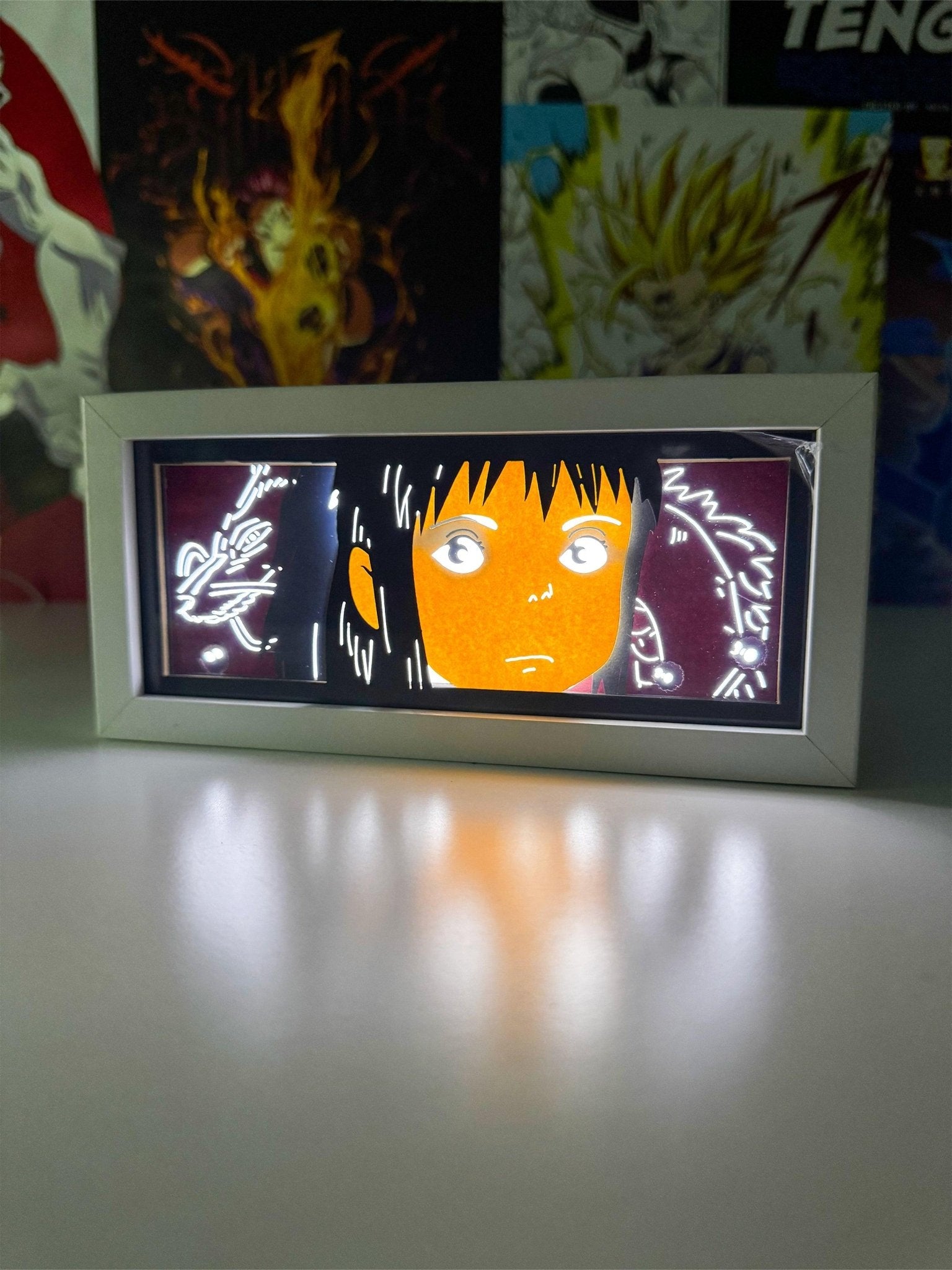 Light box con illustrazione anime in stile giapponese, luce LED e sfondo decorato con poster manga.