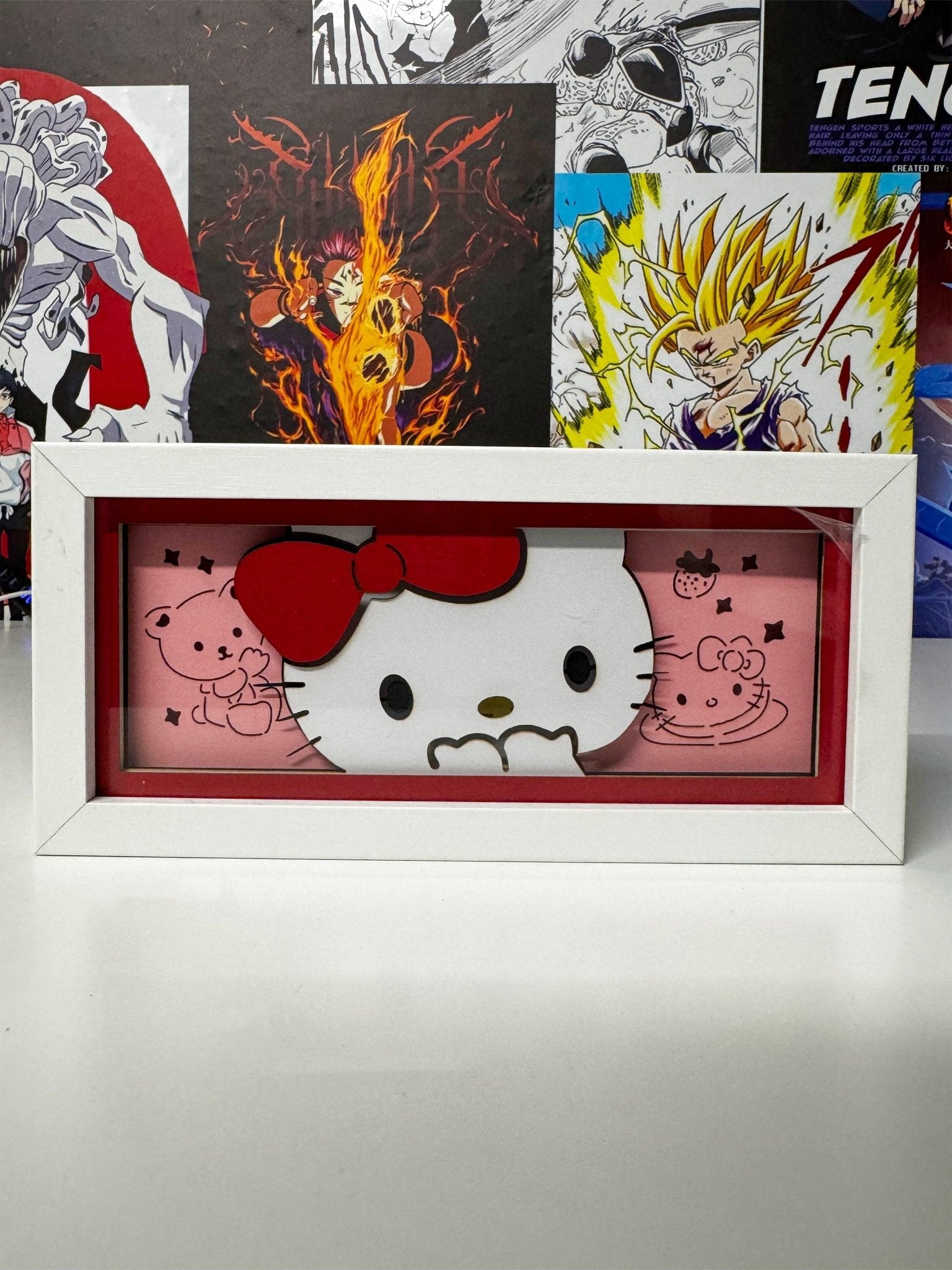 Light box decorativo Hello Kitty in cornice bianca, sfondo rosa con disegni kawaii.