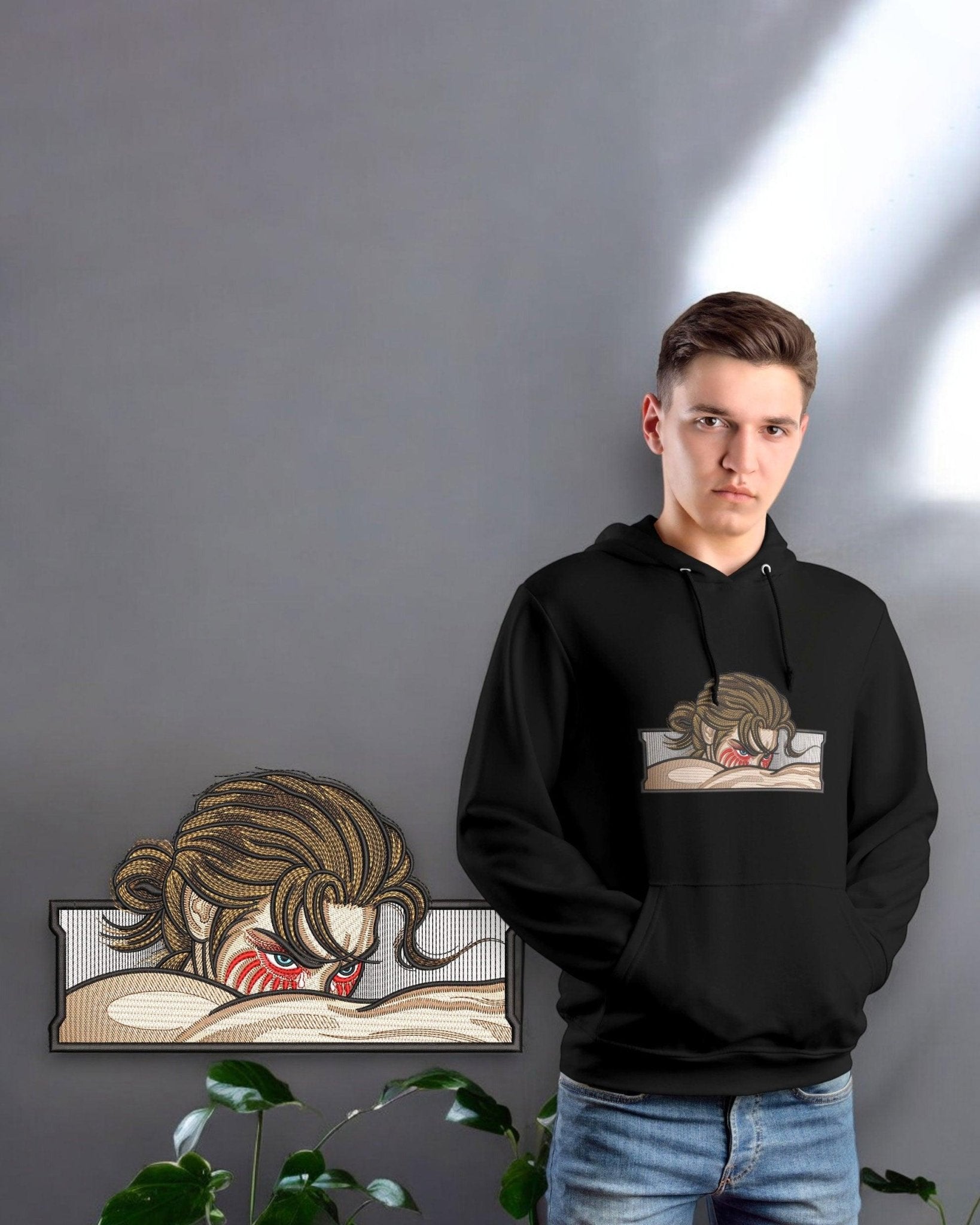Felpa nera ricamata Attack on Titan con Eren Yeager, indossata da ragazzo, sfondo grigio