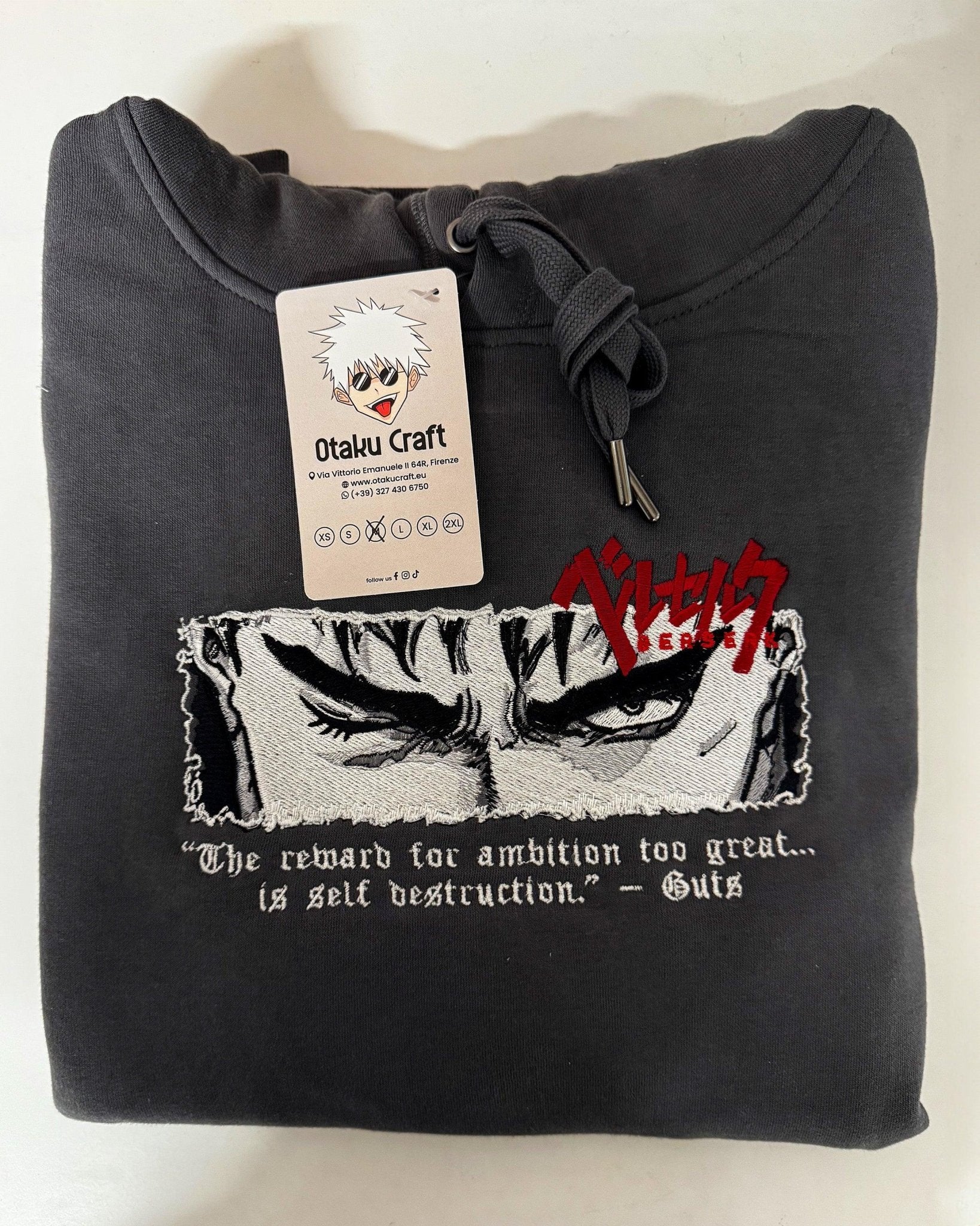 Felpa nera ricamata con occhi di Guts Berserk e scritta in inglese, etichetta anime.