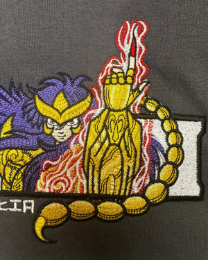 Ricamo anime di Milo dello Scorpione Saint Seiya su felpa grigia, fiammate rosse, dettagli oro