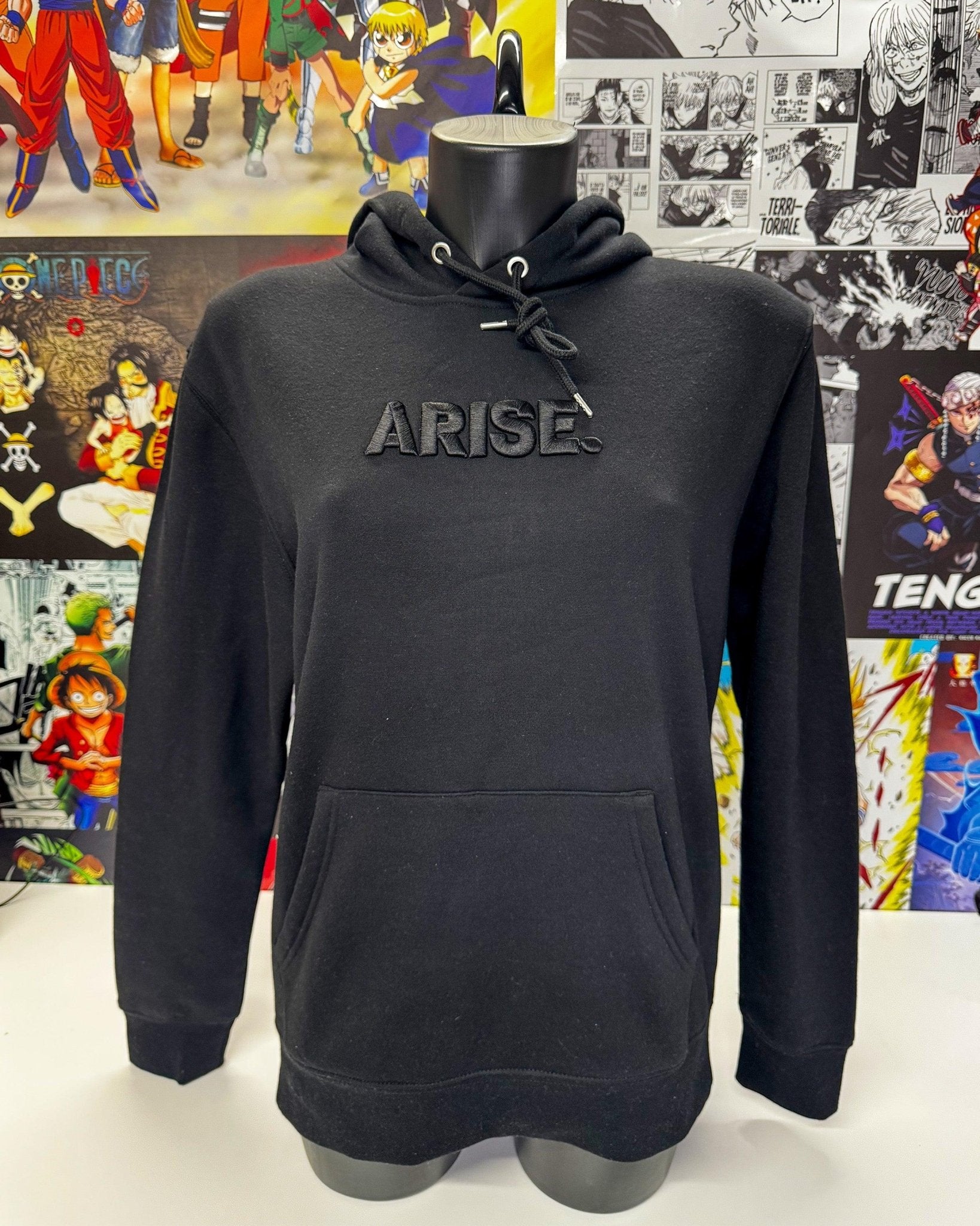 Felpa nera con cappuccio e scritta ricamata ARISE, ispirata a anime, sfondo wall manga.