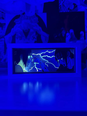 Light box LED con Itachi e Sasuke di Naruto, illuminato con effetto blu, stile anime.