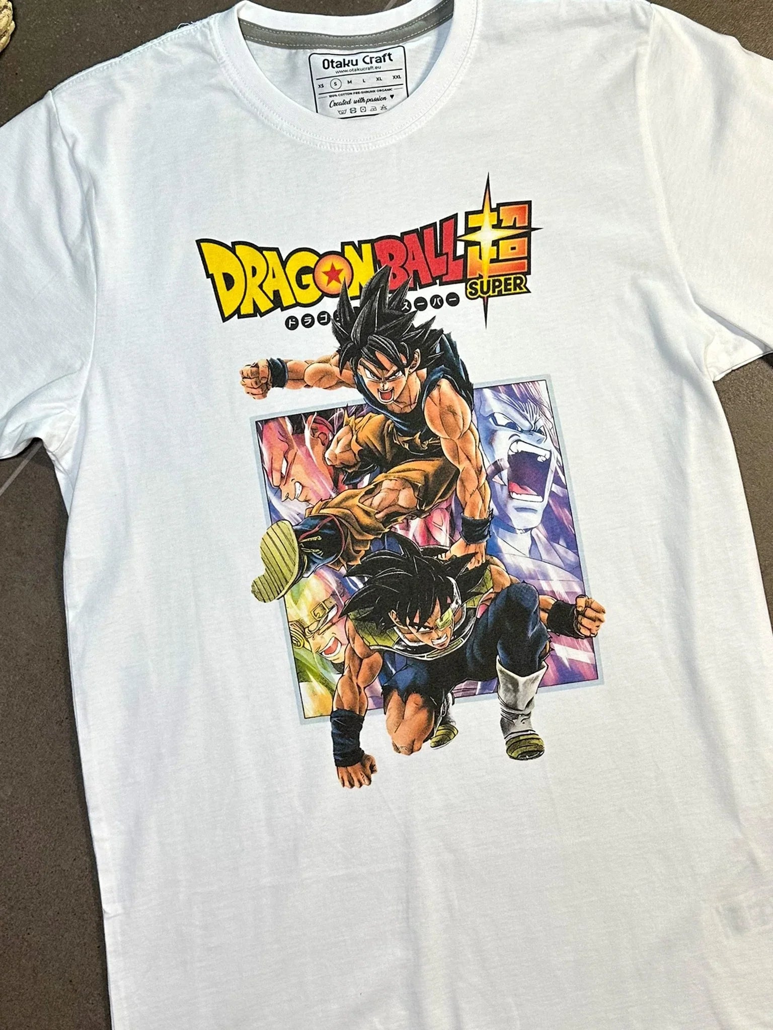 Maglietta bianca con stampa anime Dragon Ball Super, Goku e Bardock in posa dinamica.