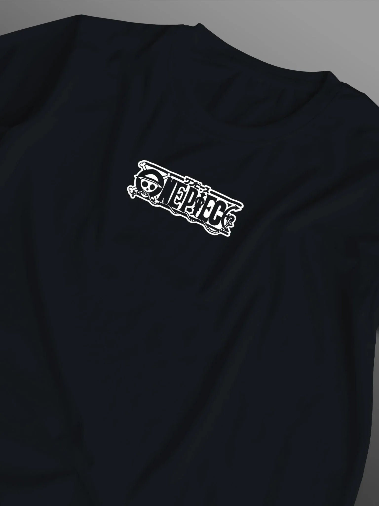 Maglietta nera con logo One Piece bianco stampato sul petto, stile anime giapponese.