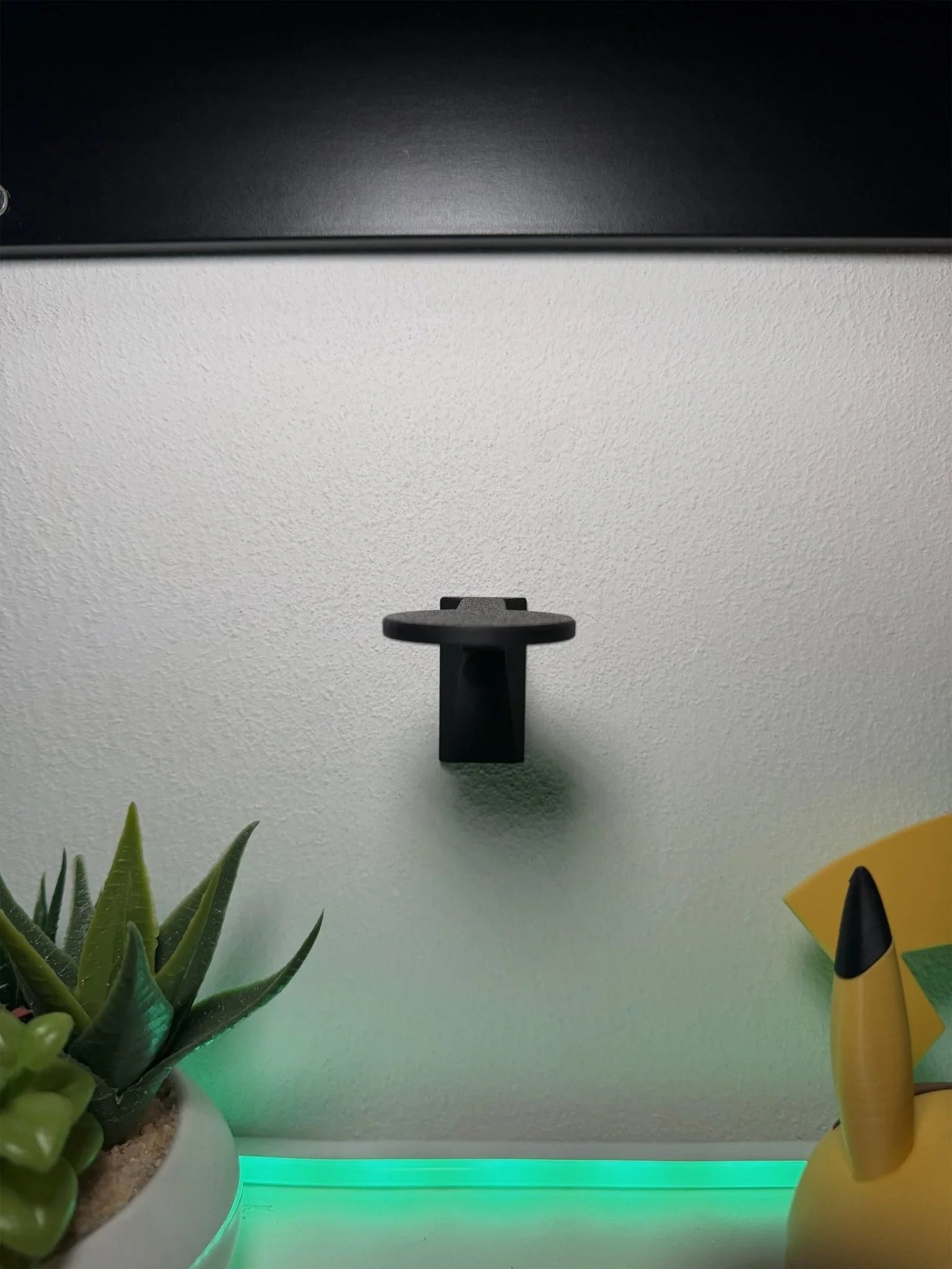 Mensolina magnetica da muro nera per Pokéball, espositore collezione Pokémon, su parete bianca.