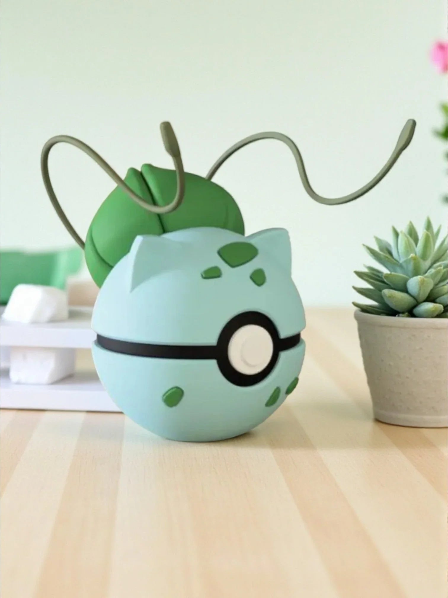 Pokeball ispirata a Bulbasaur con base magnetica, decorazione anime su tavolo in stile minimal.