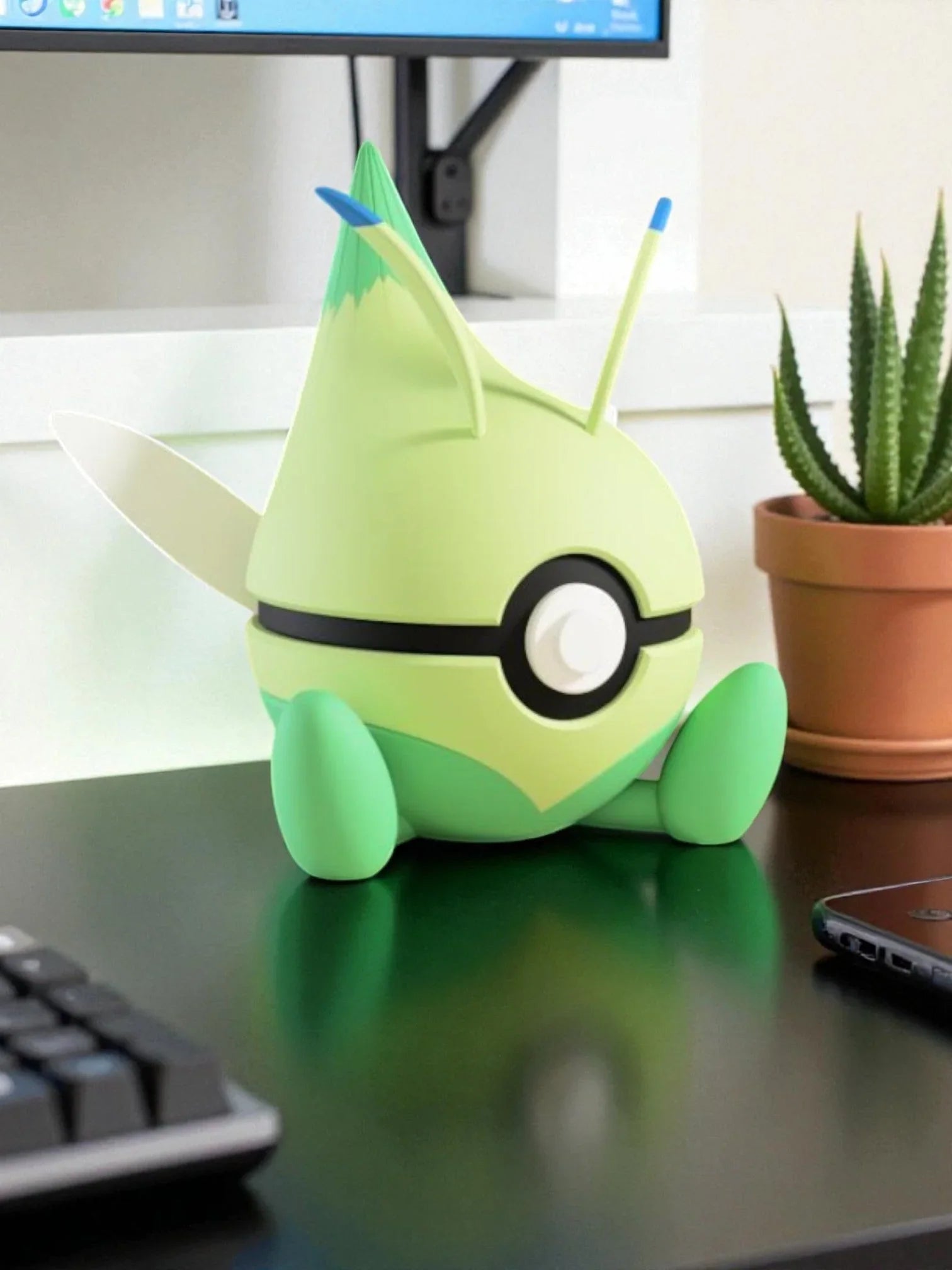 Pokeball Celebi 251 figure verde in stile anime su scrivania con pianta grassa