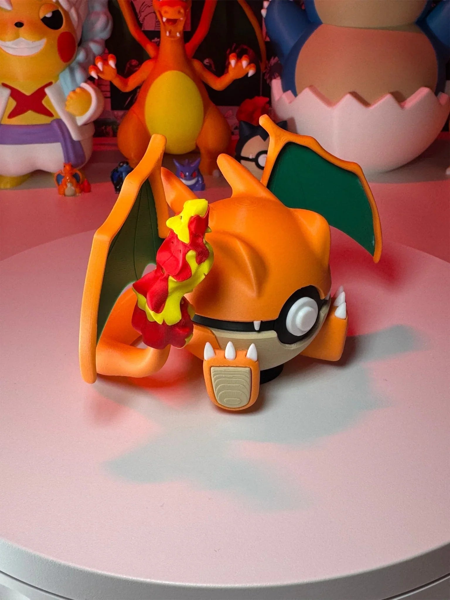 Statua collezionabile Charizard Pokéball su base magnetica, con altri personaggi anime sullo sfondo.