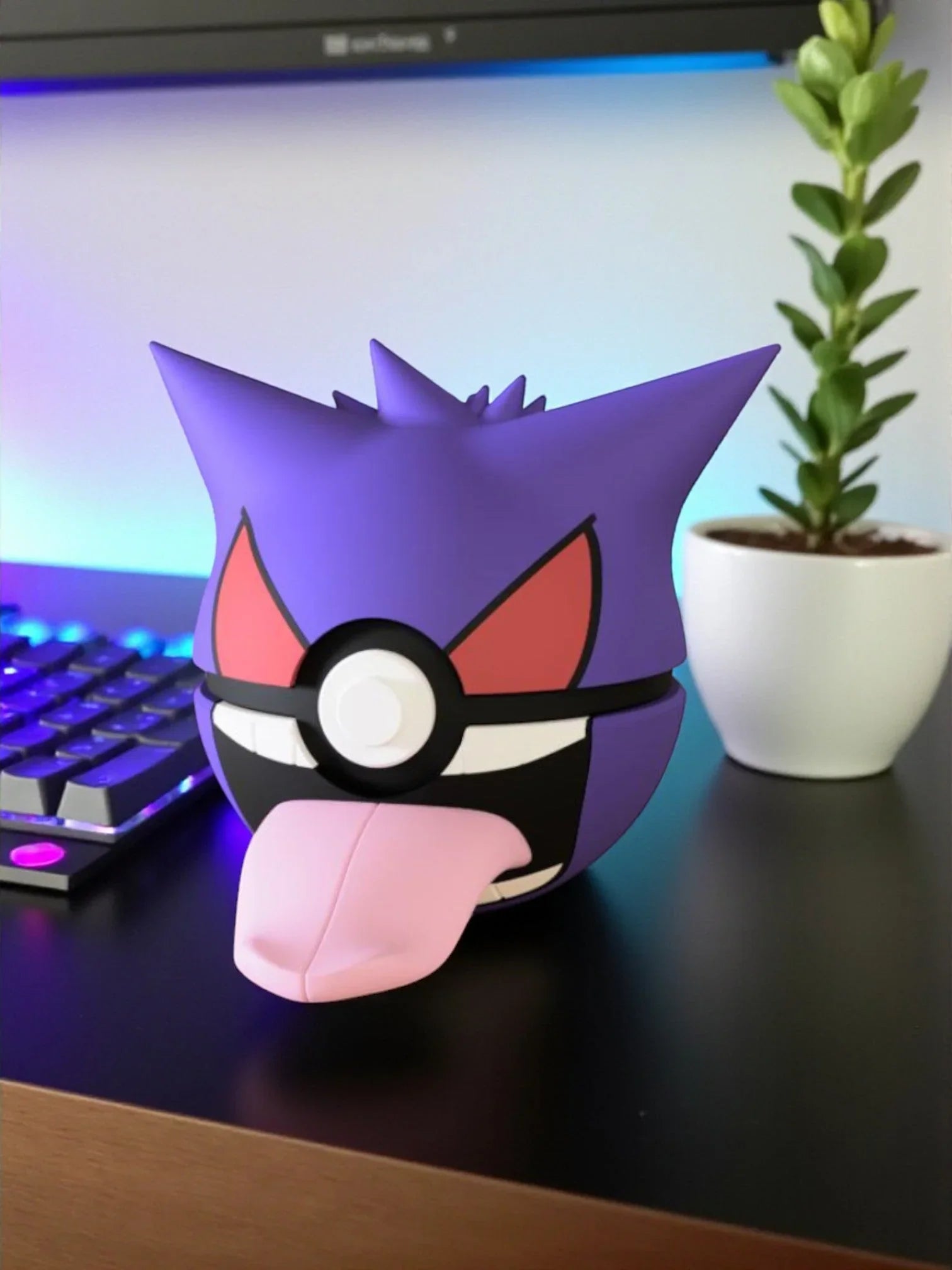 Pokeball decorativa ispirata a Gengar su scrivania con tastiera e piantina