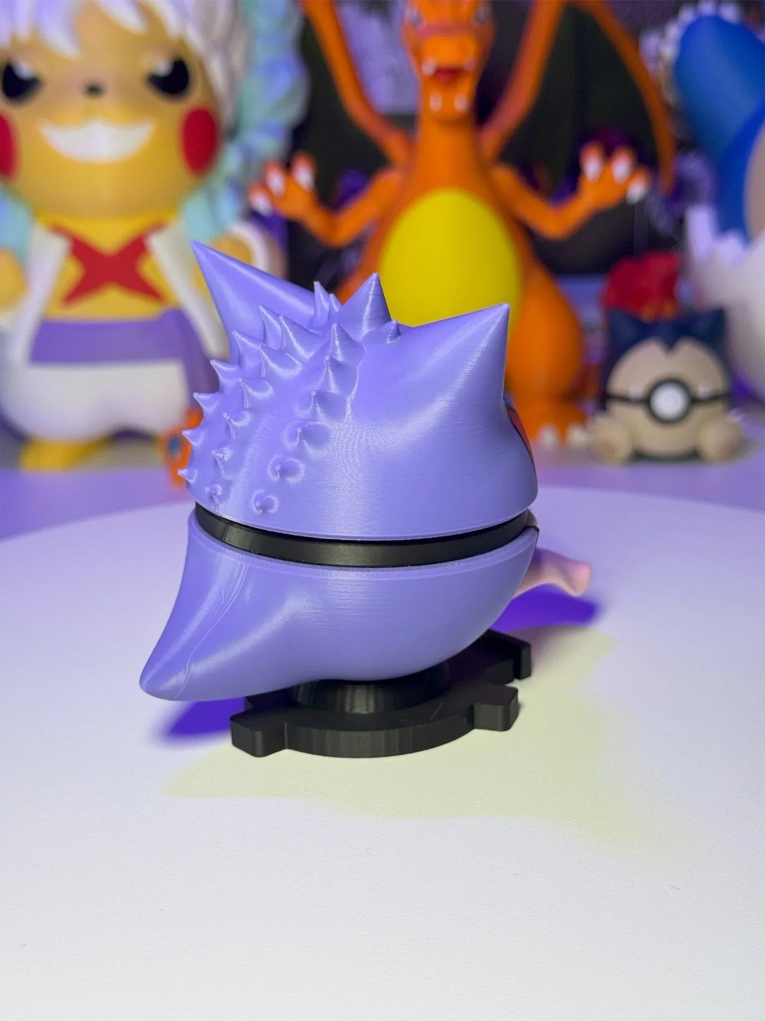 Pokeball personalizzata Gengar in plastica viola su base magnetica, con figure anime sullo sfondo