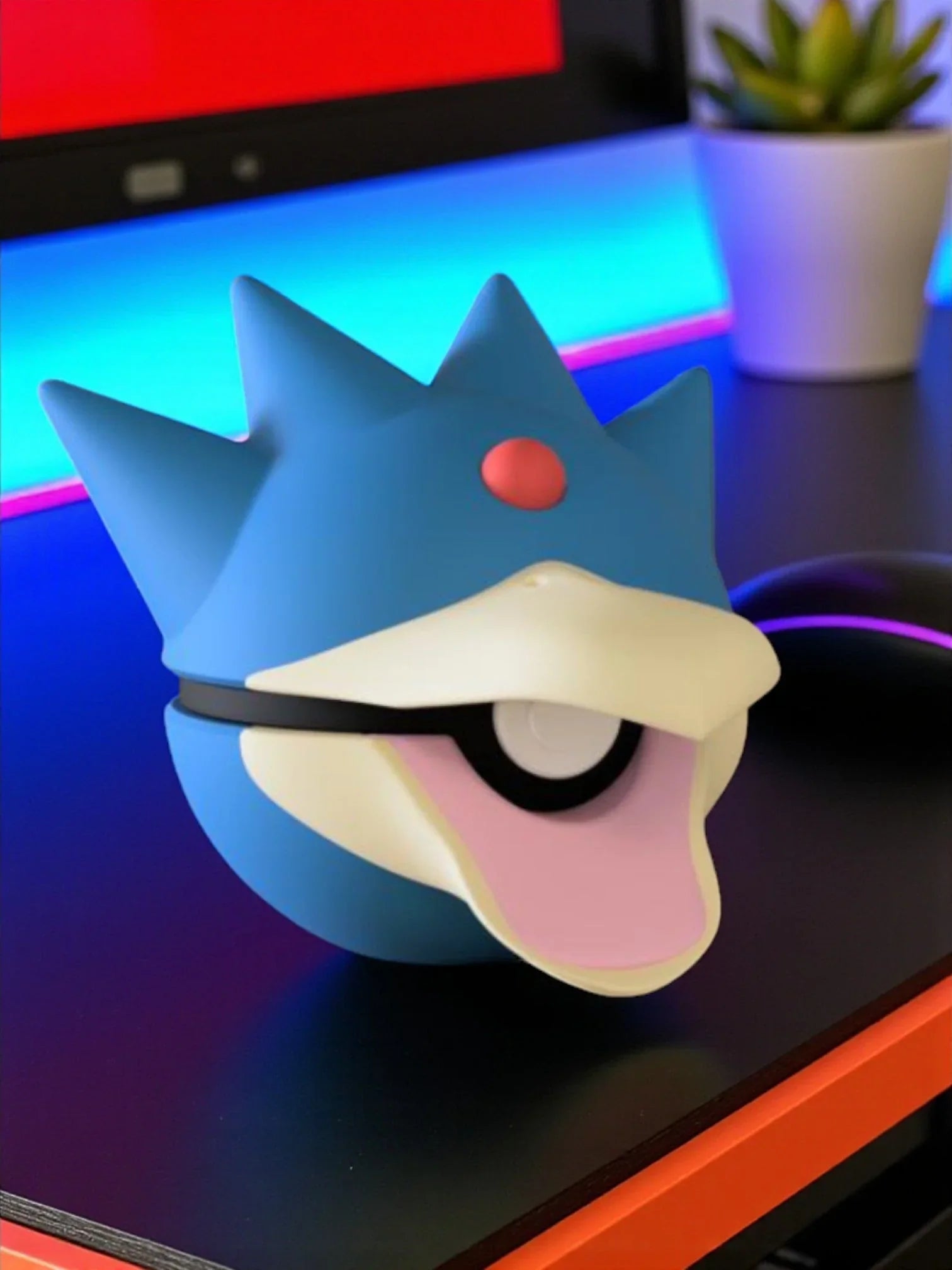 Pokéball ispirata a Golduck, base magnetica, su scrivania con sfondo gaming colorato