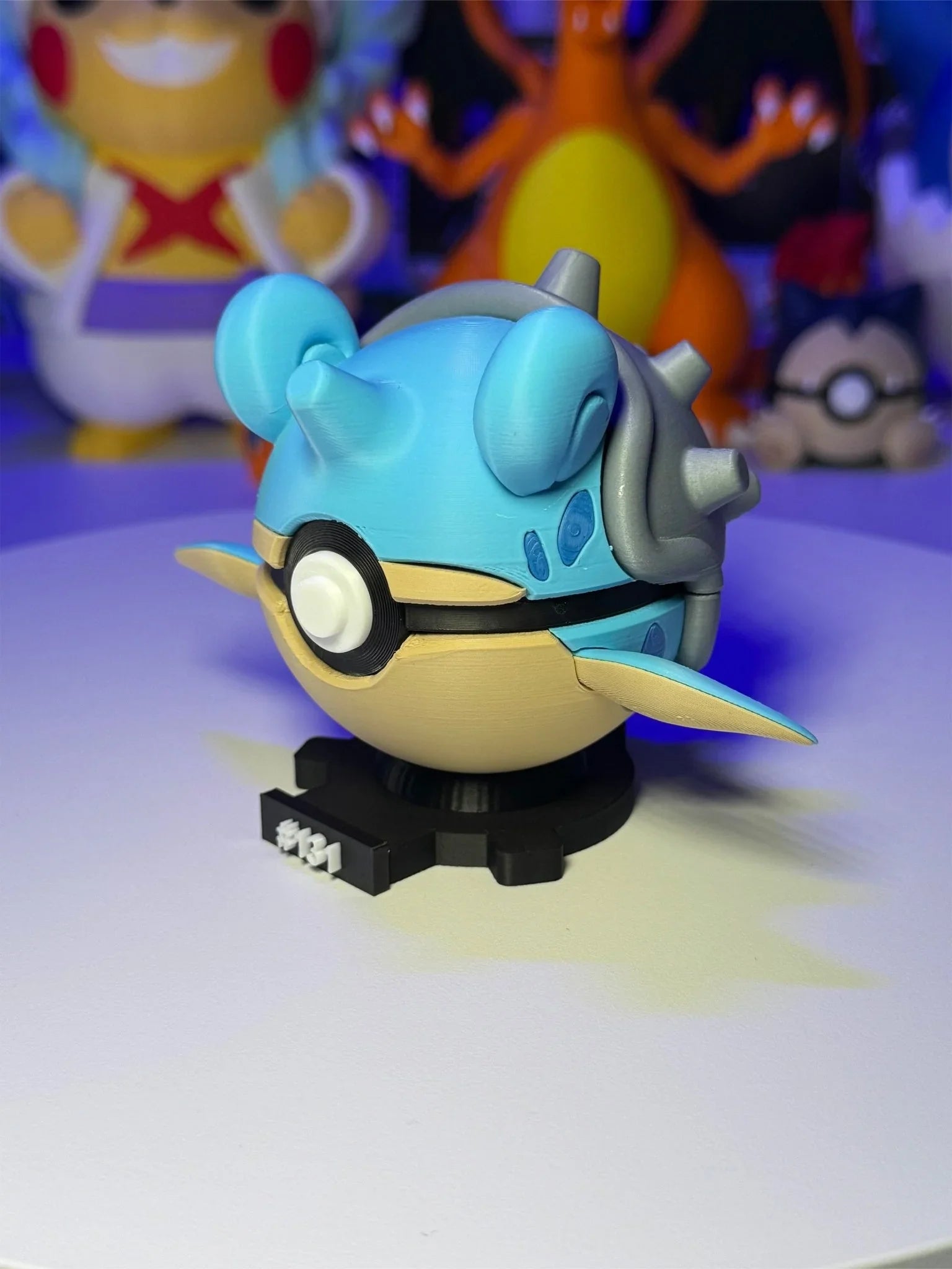 Pokeball Lapras #131 con base magnetica numerata, figura anime in primo piano su sfondo colorato.