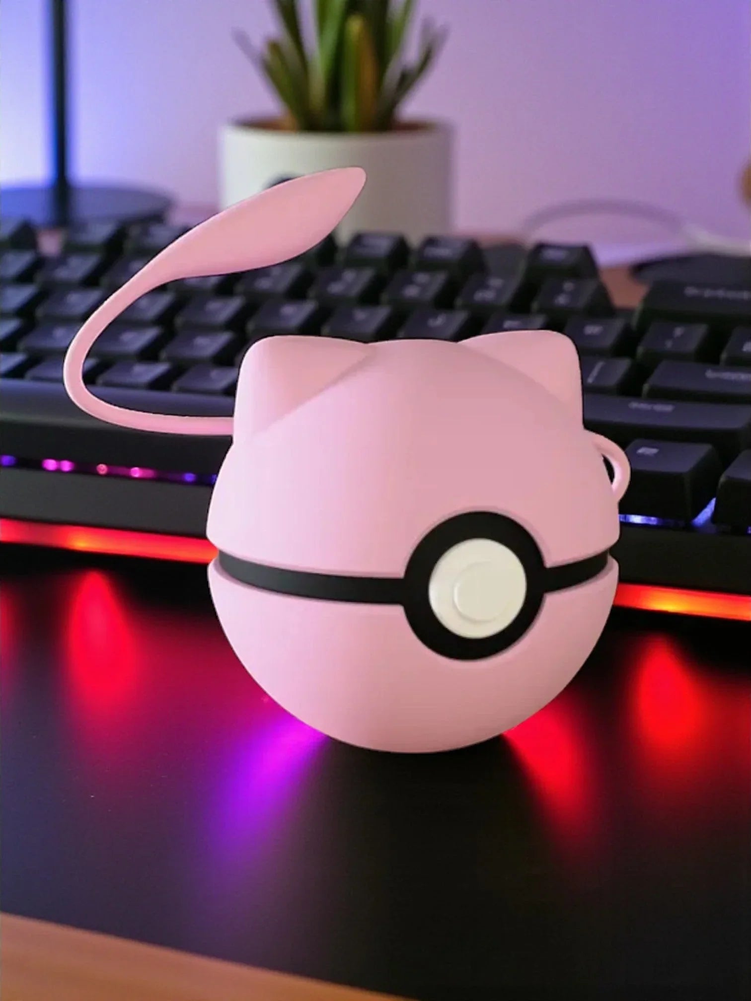Pokeball rosa ispirata a Mew, con base magnetica, su scrivania davanti a tastiera RGB