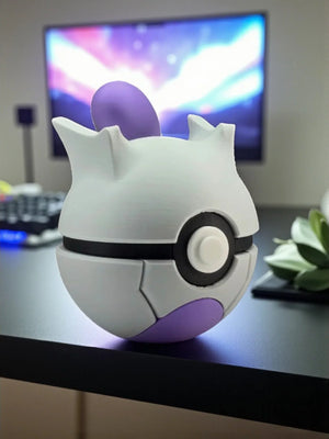 Pokeball Mewtwo edition decorativa bianca e viola su scrivania con sfondo monitor acceso.