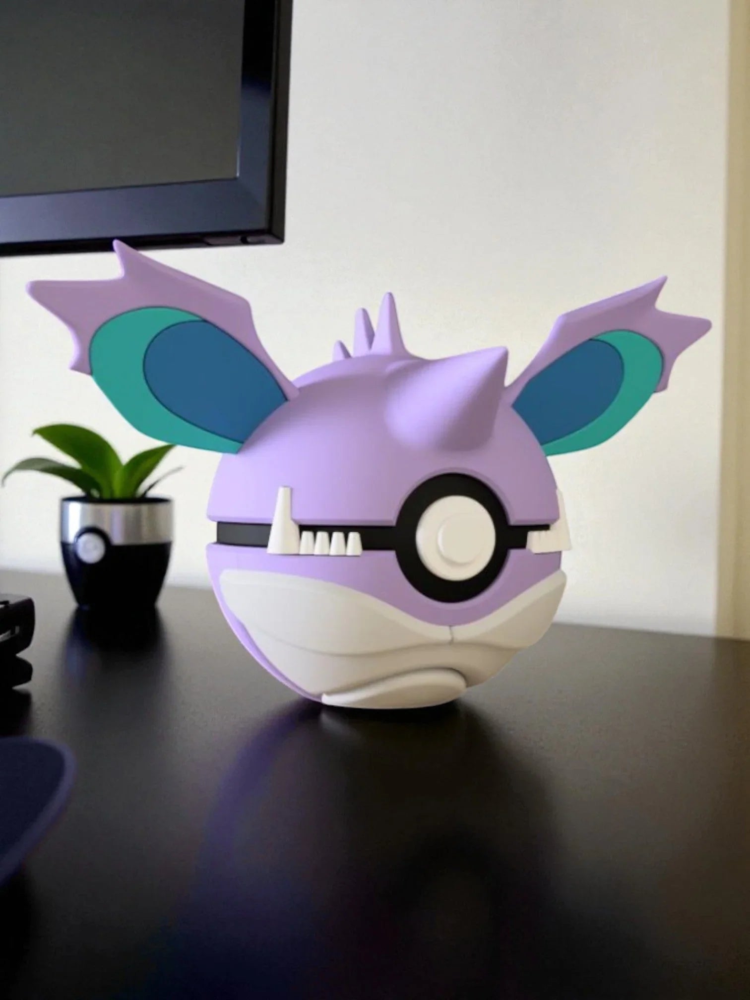 Pokeball personalizzata ispirata a Nidoking viola e bianca su scrivania, oggetto da collezione anime.