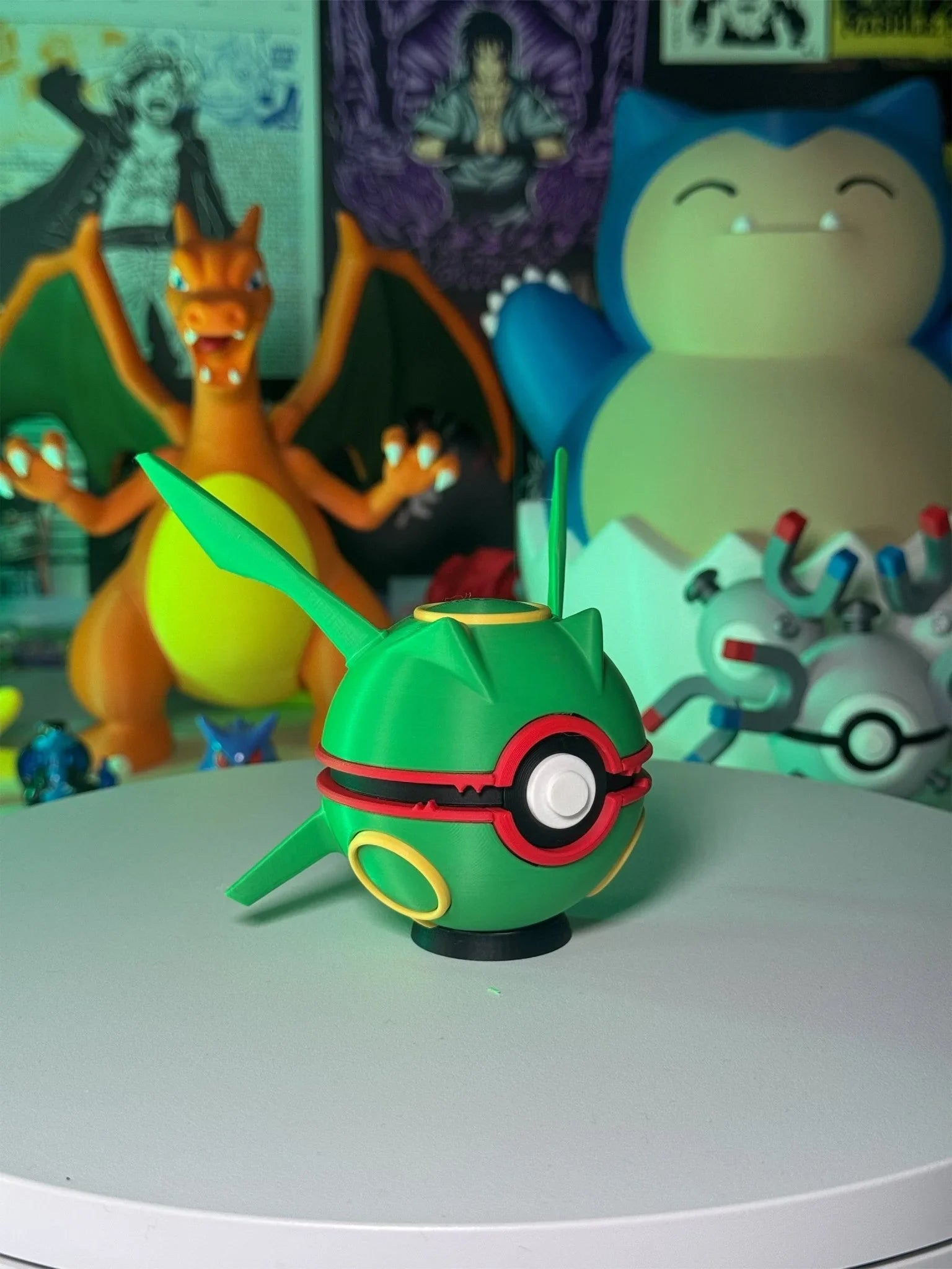 Pokéball stile Rayquaza su base magnetica, con figure di Pokémon in sfondo.