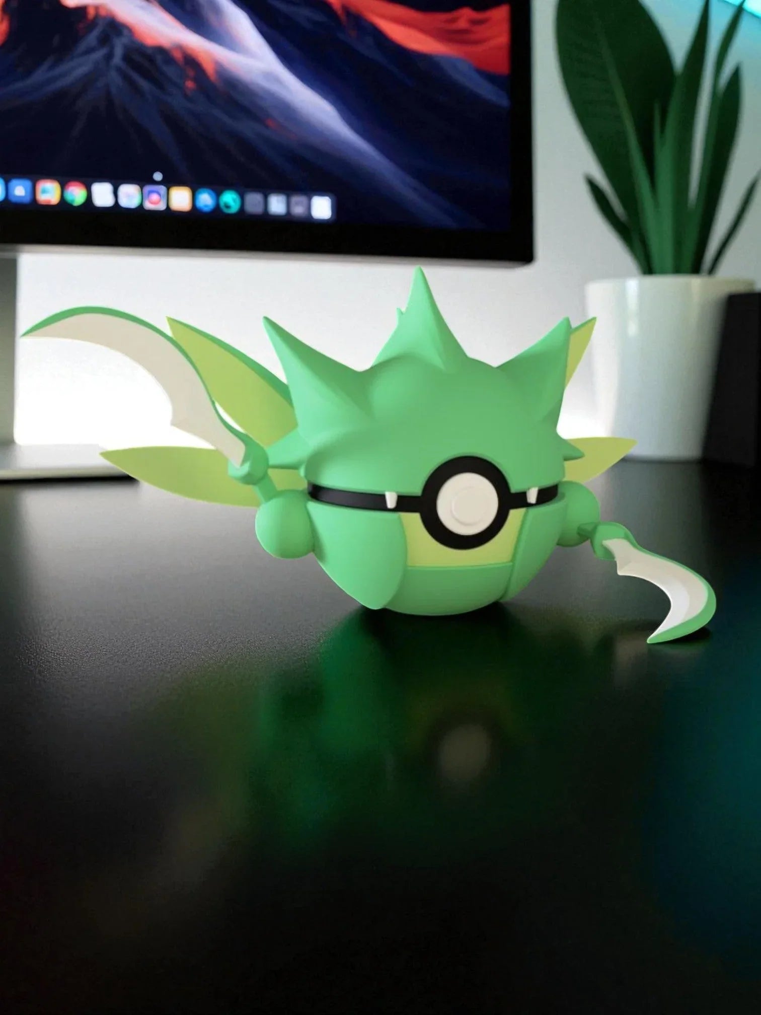 Figura Pokeball Scyther verde, stile anime, su scrivania nera con computer e pianta.